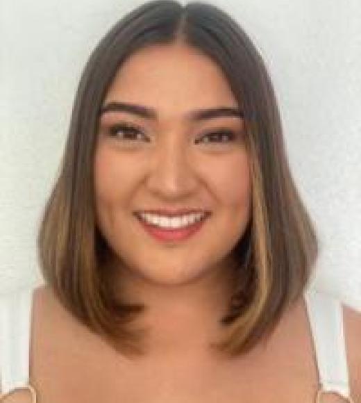 A young woman with a straight brown bob smiles widely.