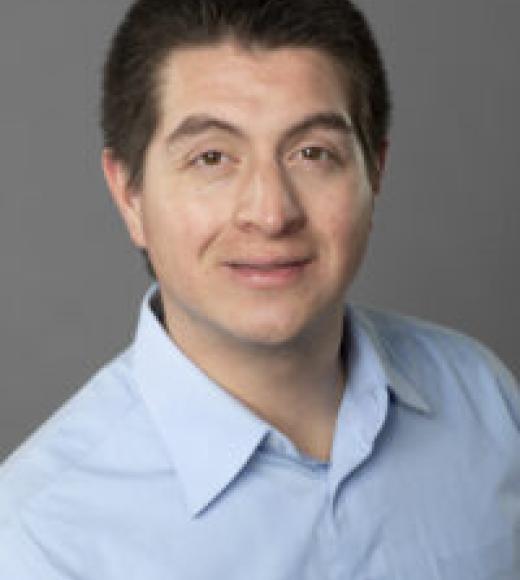 Headshot of a man with close-cropped hair and a blue shirt.