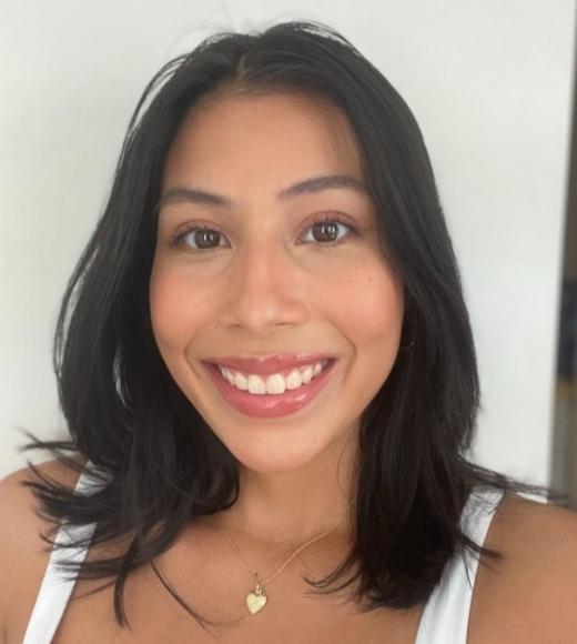 A young woman with dark, short hair smiles widely.