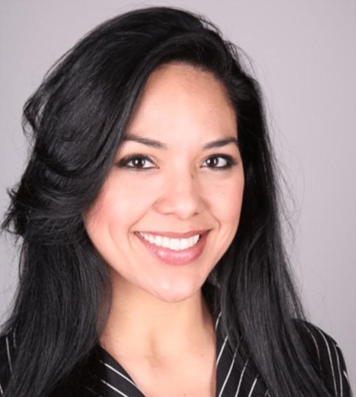 A woman with straight, black hair smiles widely.