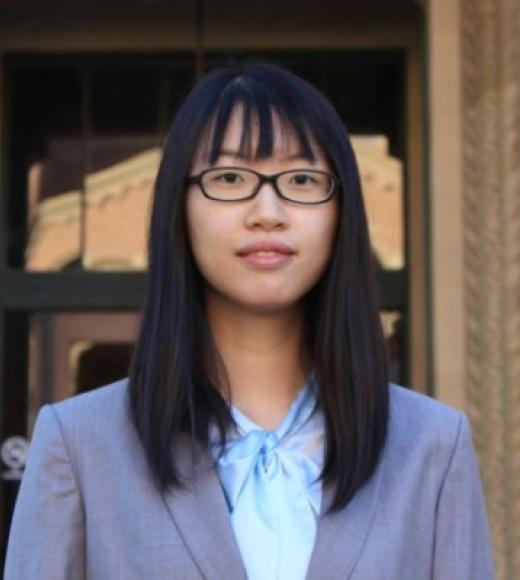 A young person with straight black hair, glasses, and semiformal attire.